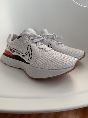 Nike White Knit Running Sneakers with Black Swoosh and Coral Heel Accent